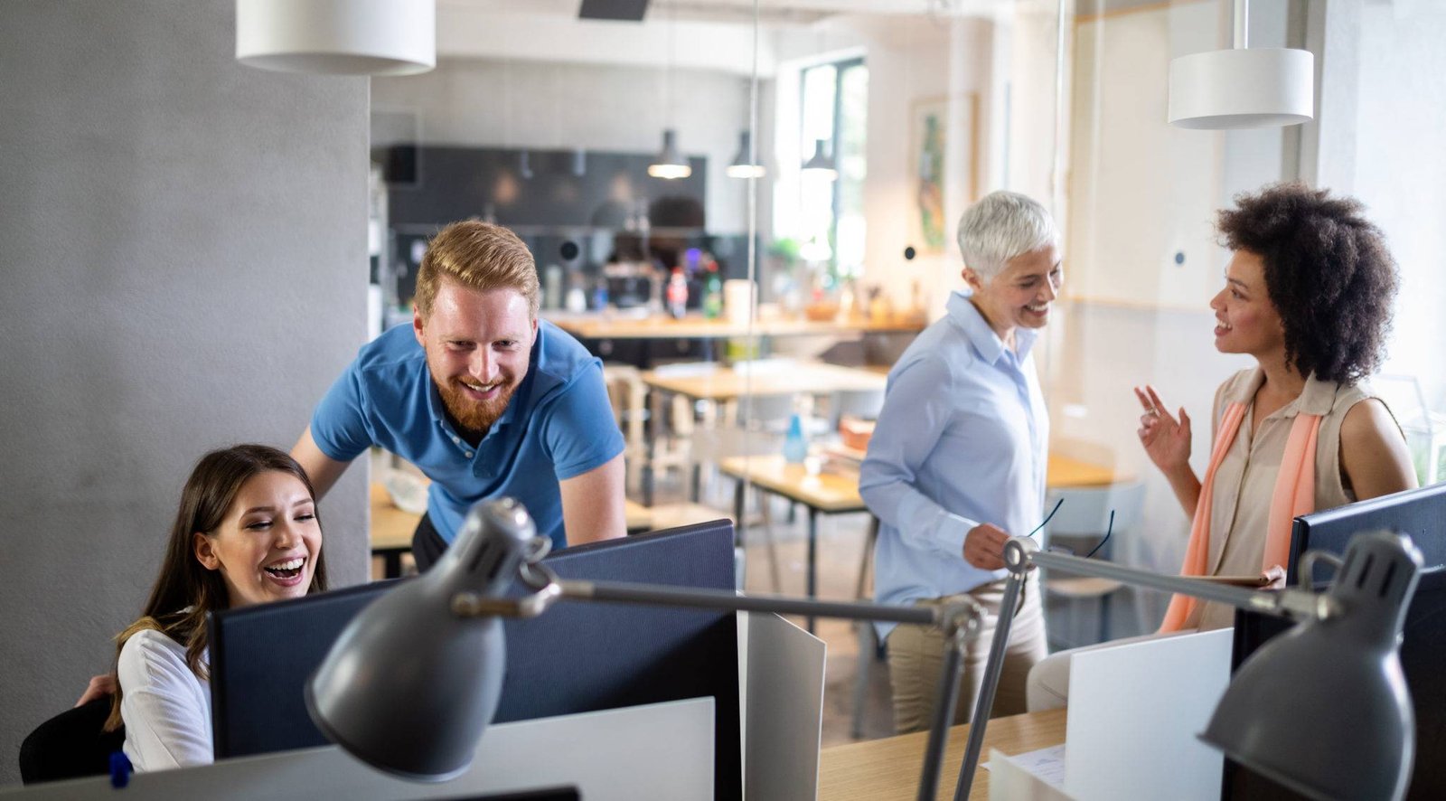 Colleagues chatting across desks in an open-plan office