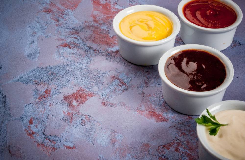 Bowls of colourful dipping sauces on a marble surface