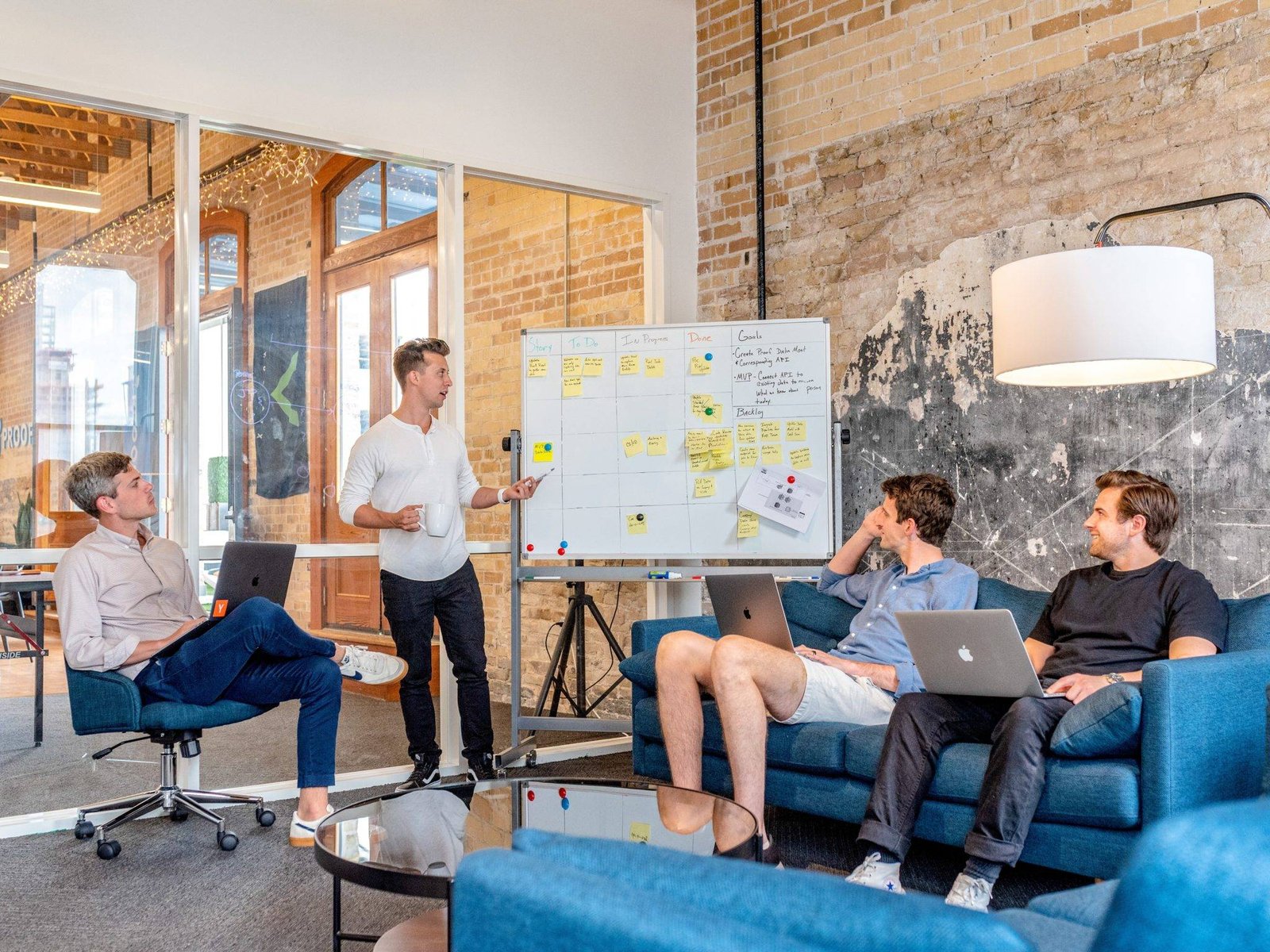 Young team holding an informal meeting on sofas in a brick-walled office