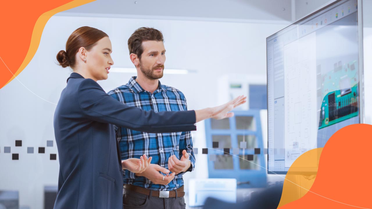 Two colleagues pointing at an interactive learning screen