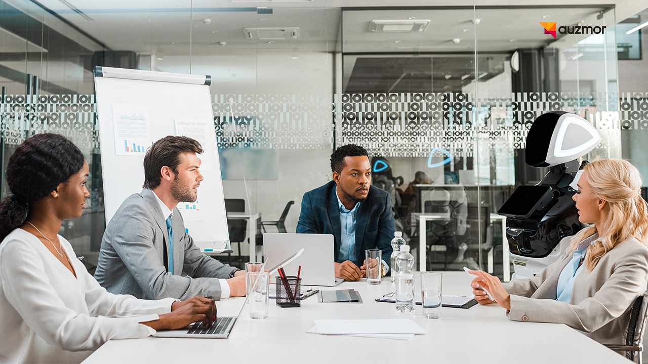 Team meeting around a conference table with laptops and a whiteboard