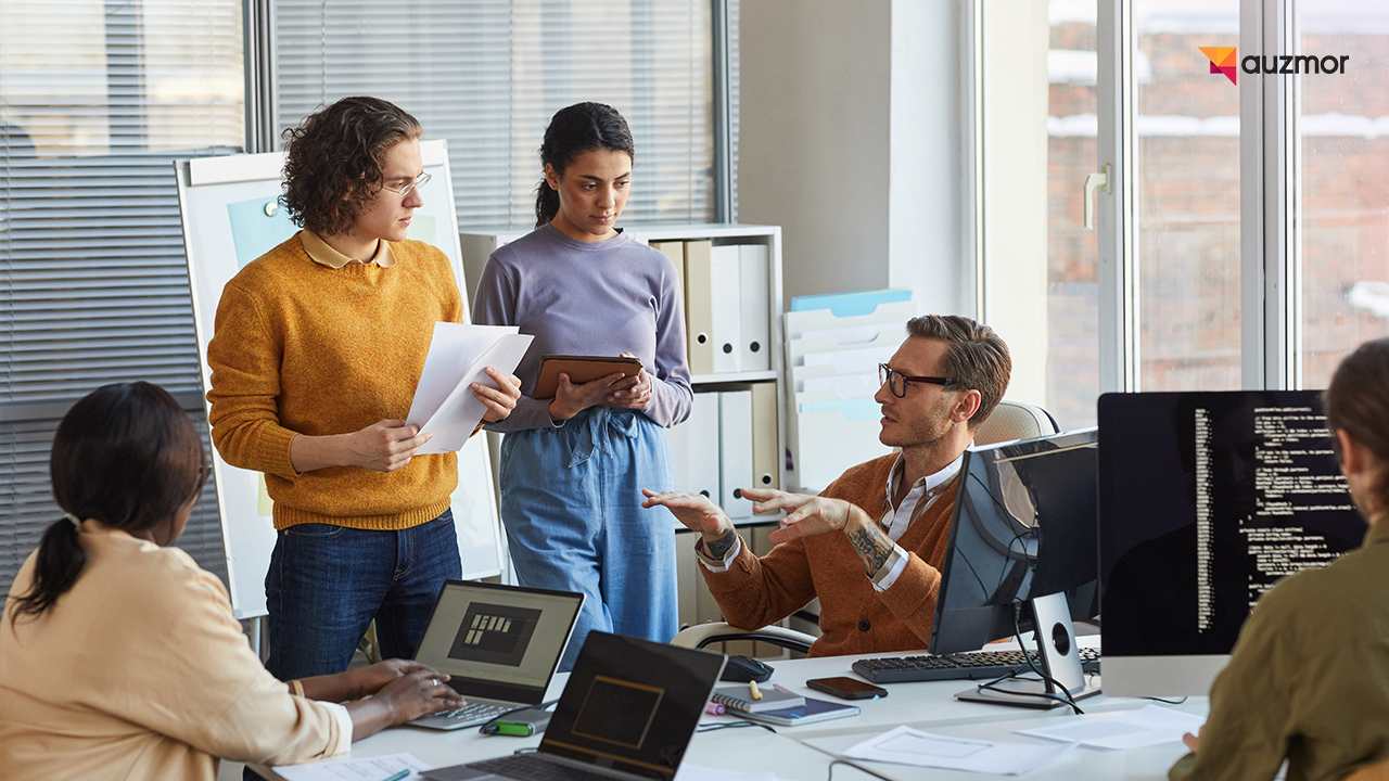 Team reviewing papers and screens together while discussing AI governance in an office