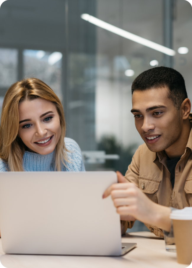 Two colleagues learning together at a laptop in the office