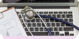 Stethoscope and clipboard on a laptop keyboard, illustrating the cost of HIPAA violations