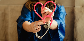 Healthcare worker holding a heart-shaped stethoscope, representing custom healthcare compliance training
