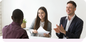 Interviewers smiling and applauding a job candidate during a hiring interview