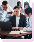 Colleagues gathered around a laptop in a team training session