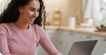 Woman smiling while learning on a laptop