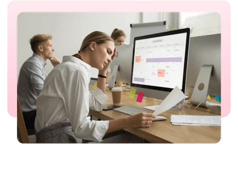 Colleagues working at desktop computers in a busy office