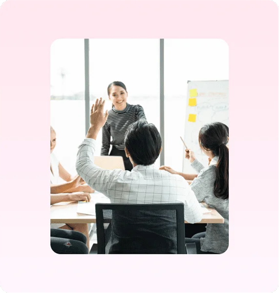 Students raising hands in a classroom training session