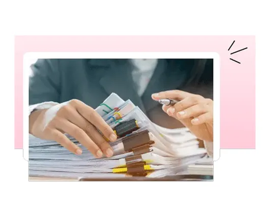 Hands sorting through a large stack of paper files