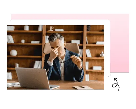 Stressed man at a desk with his head in his hands
