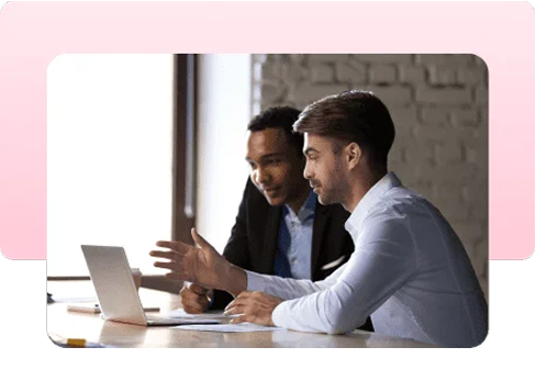 Two colleagues discussing work at a laptop