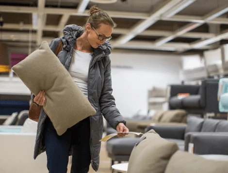 Shopper carrying a cushion through a furniture showroom