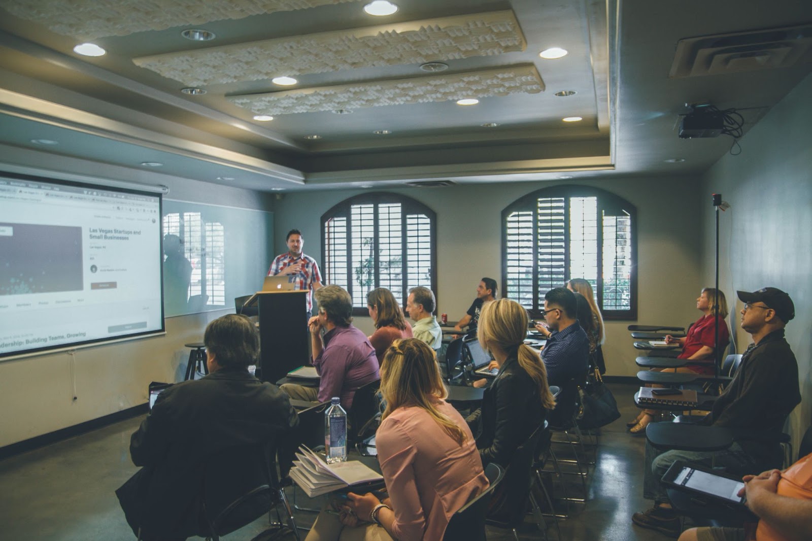 Speaker presenting to a diverse audience in a seminar room