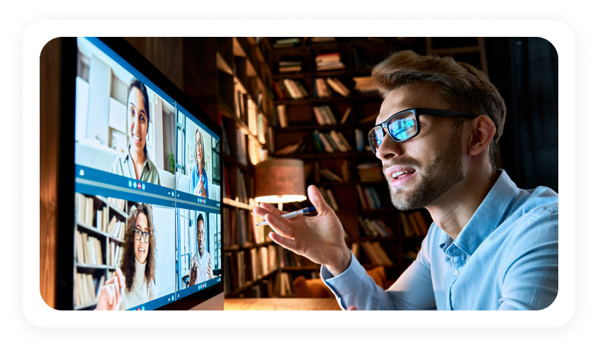 Recruiter on a video call with candidates shown on a large screen