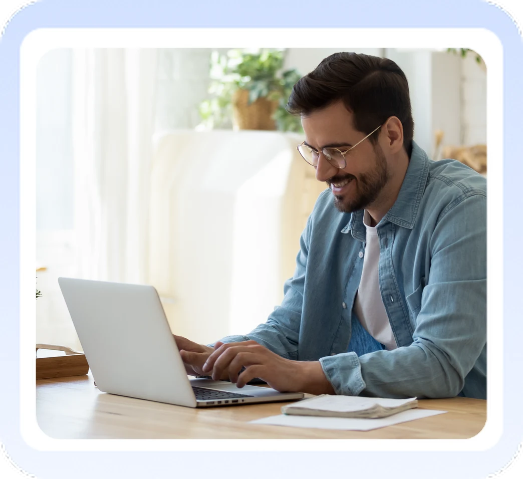 Smiling man working on his laptop at home