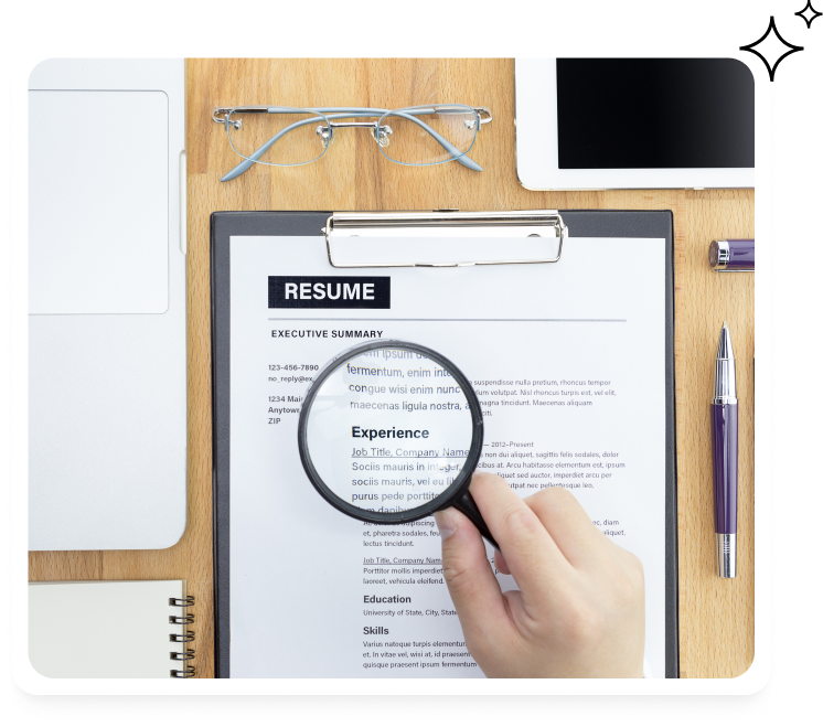 Magnifying glass over a printed resume on a desk