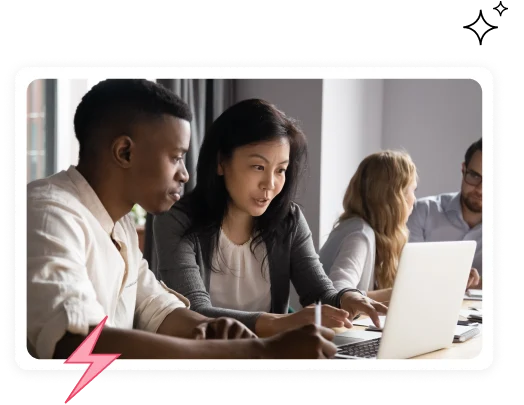 Colleagues reviewing work together on a laptop