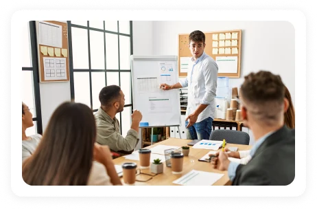 Trainer presenting at a whiteboard to a team during onboarding
