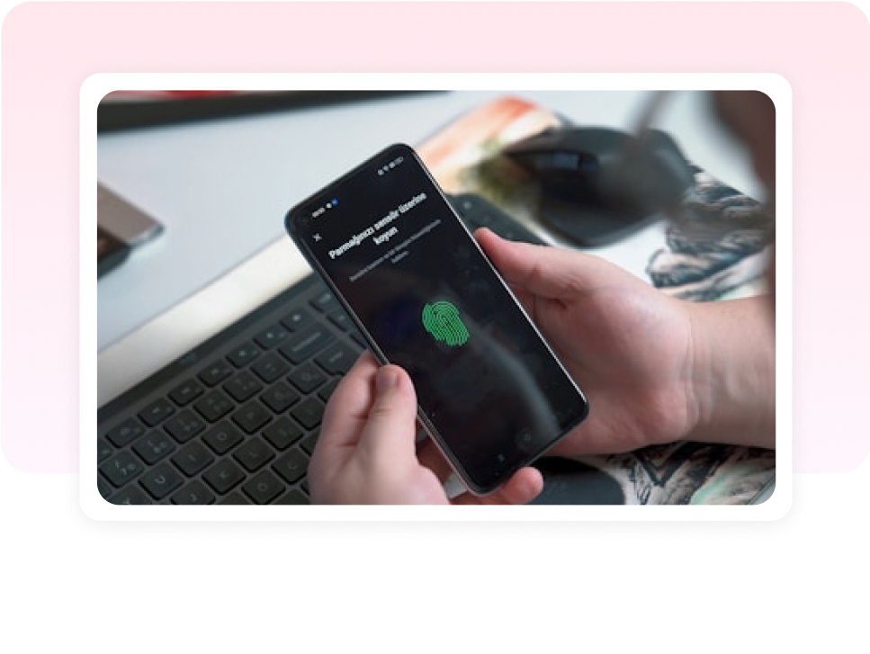 Hand holding a phone with a fingerprint scan for secure identity and access