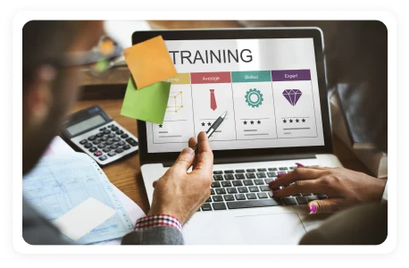 Laptop showing a training dashboard while a learner takes notes with a calculator